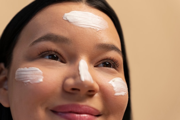 写真 顔に保湿剤を使用している女性の肖像画