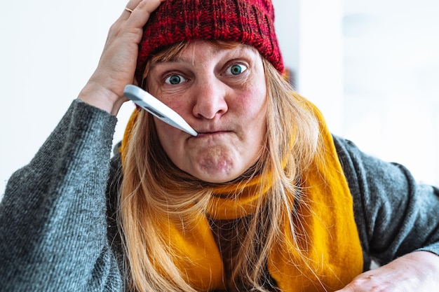 写真 寒い冬に口の中に温度計を持つ女性の肖像画