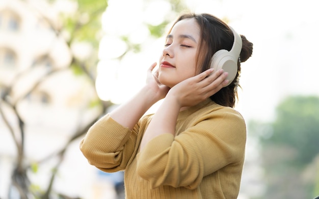 사진 공원에서 음악을 듣고 젊은 아시아 여자의 초상화