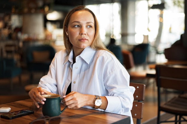 カフェでコーヒーを飲む若いビジネス女性の肖像画