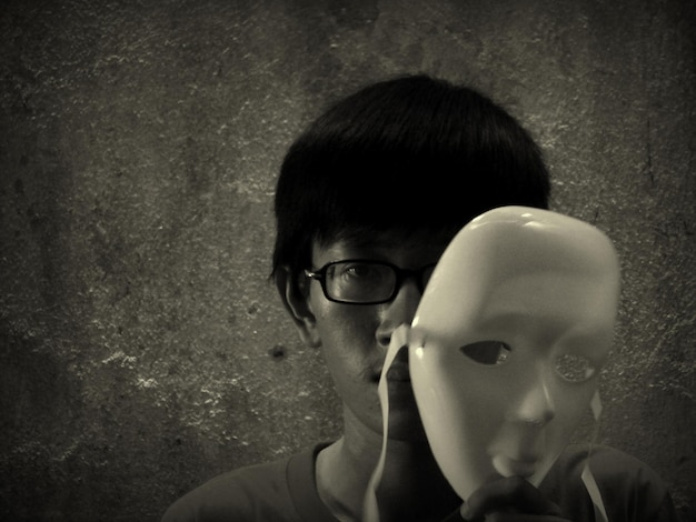 Фото Портрет молодого человека с маской на стене