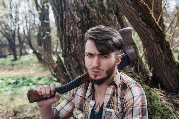 写真 森で武器を握っている若者の肖像画