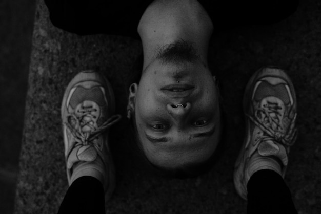Фото Портрет молодого человека с ногами, близкими к лицу