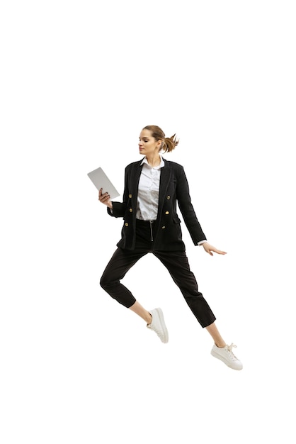 Фото Портрет молодой красивой девушки в деловой одежде, прыгающей на белом фоне