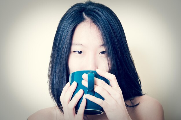 写真 白い背景にコーヒーを飲んでいる若い女性の肖像画