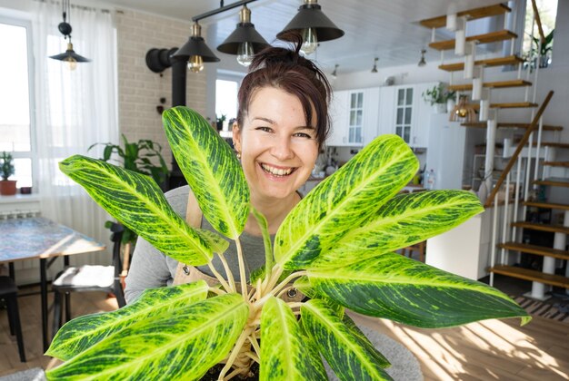 Фото Портрет молодой женщины, держащей растение