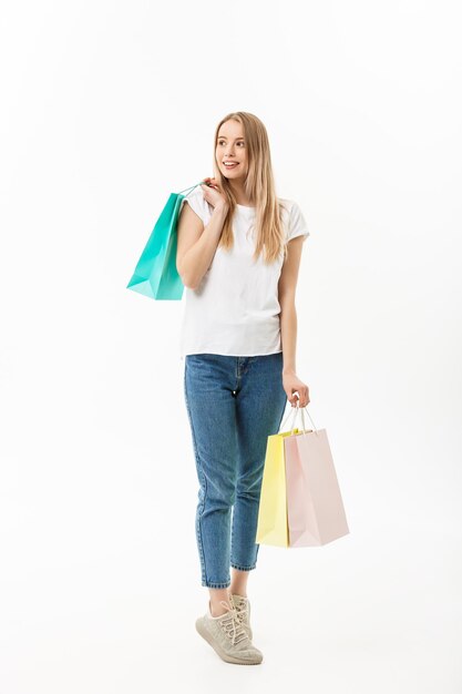 Фото Портрет молодой женщины с сумками для покупок, стоящей на белом фоне