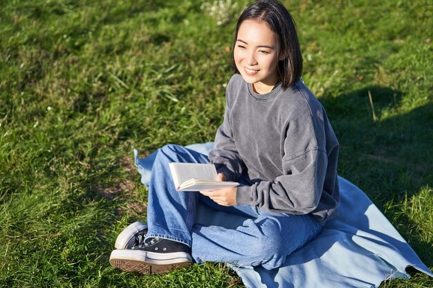 사진 잔디에 앉아 있는 젊은 여성의 초상화