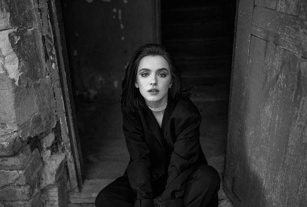 Фото Портрет молодой женщины, сидящей на стене