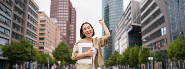 写真 建物に寄りかかって立っている若い女性の肖像画