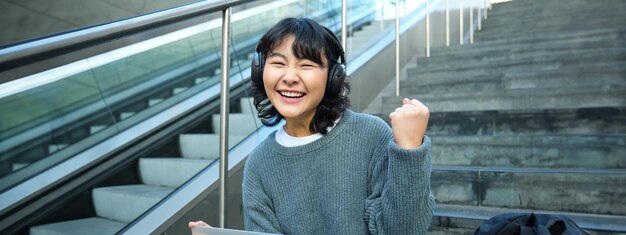 写真 エスカレーターに向かって立っている若い女性の肖像画