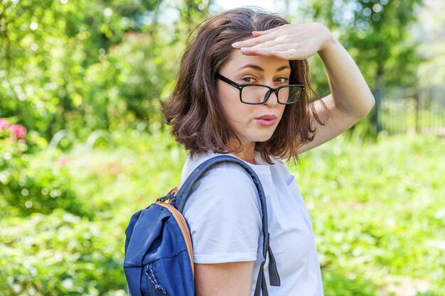 写真 植物に寄りかかって立っている若い女性の肖像画