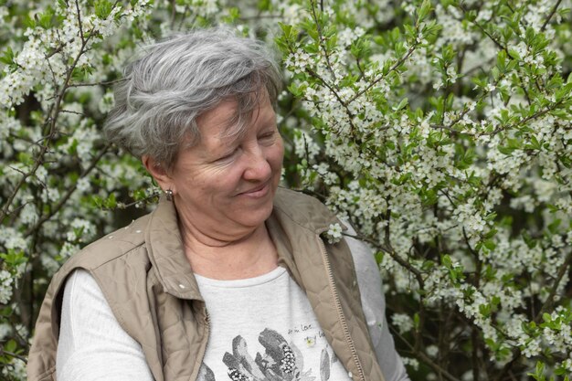 写真 植物に寄りかかって立っている若い女性の肖像画