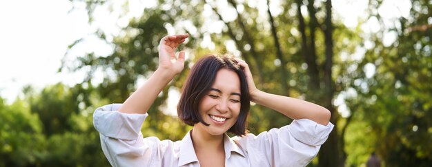 写真 木に寄りかかって立っている若い女性の肖像画