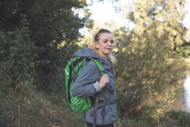 写真 木に寄りかかって立っている若い女性の肖像画