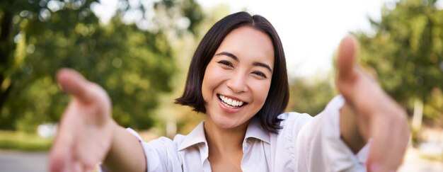 写真 木に寄りかかって立っている若い女性の肖像画