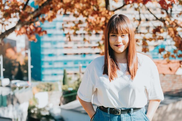 写真 木に寄りかかって立っている若い女性の肖像画