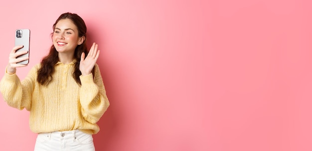 写真 黄色い壁に立っている若い女性の肖像画