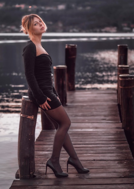 Фото Портрет молодой женщины, стоящей на пирсе