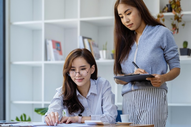 写真 テーブルに座って携帯電話を使っている若い女性の肖像画