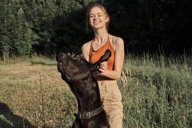 写真 野原で犬を飼っている若い女性の肖像画