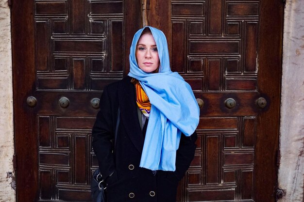 写真 ドアに立つスカーフをかぶった若い女性の肖像画