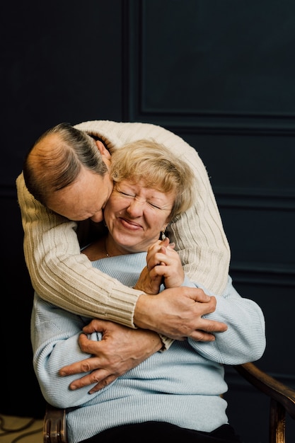 Foto ritratto di vecchia coppia moglie e marito abbracciando e sorridente. sfondo blu scuro. amanti felici in pensione. stop all'età. . foto di alta qualità