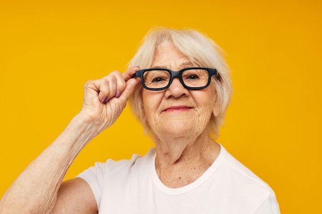 Photo portrait of an old friendly woman health lifestyle eyeglasses isolated background