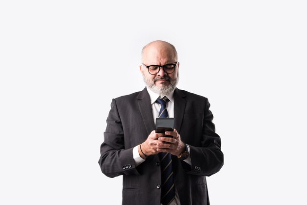 Portrait of old Indian asian businessman using smartphone for messaging, calling or showing or presenting against white background