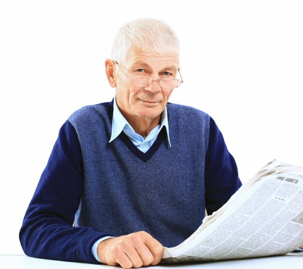 Portrait of an old man solving crosswords in the newspaper