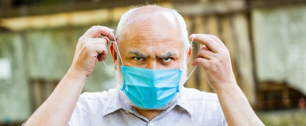 외과 붕대, 코로나 바이러스, 의료 마스크에 초상화 노인. 얼굴 마스크를 착용하는 노인.
