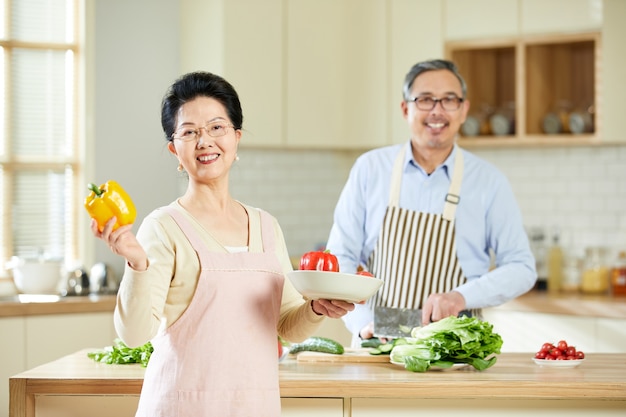 Portrait an old married couple looks cheerful in the kitchen room