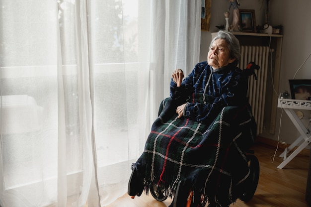 Portrait old sick woman sitting in wheelchair at home. third
age, home elderly assistance concept.