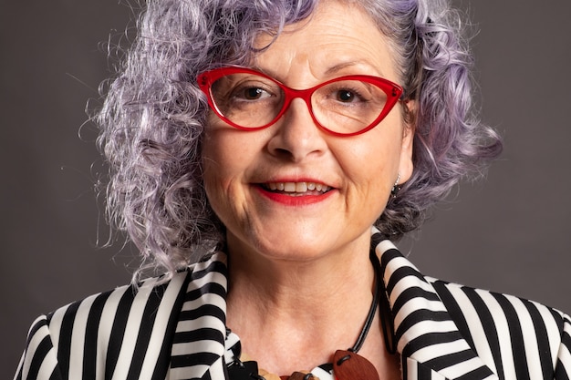 Portrait of old woman smiling with red eyeglasses