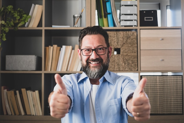 Portrait of one happy and cheerful man smiling and looking at the camera with finger's hand up. Male person businessman having fun after receive good news of work