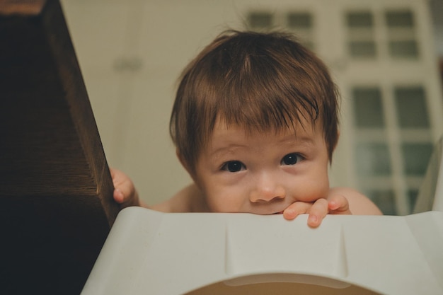 portrait of a one-year-old child in close-up looking out of a high chair