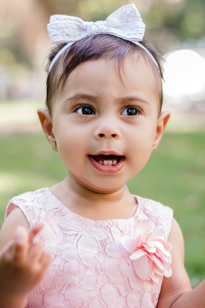 楽しんで、庭で笑っている 1 歳の女の子の肖像画