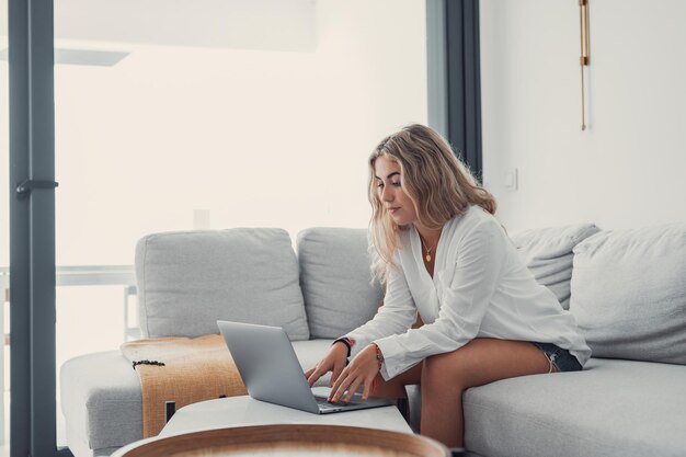 Portrait of one young attractive blonde woman using laptop