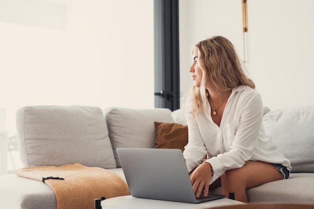 Portrait of one young attractive blonde woman using laptop