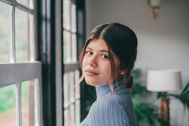 Portrait of one young beautiful and attractive woman smiling and enjoying having fun looking at the camera alone at home Close up of female person relaxing indoorxA