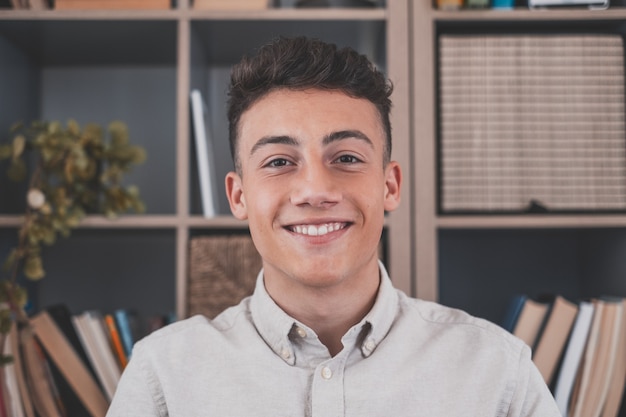 Portrait of one young and happy cheerful man smiling looking at the camera having fun. Headshot of male person working at home in the office.