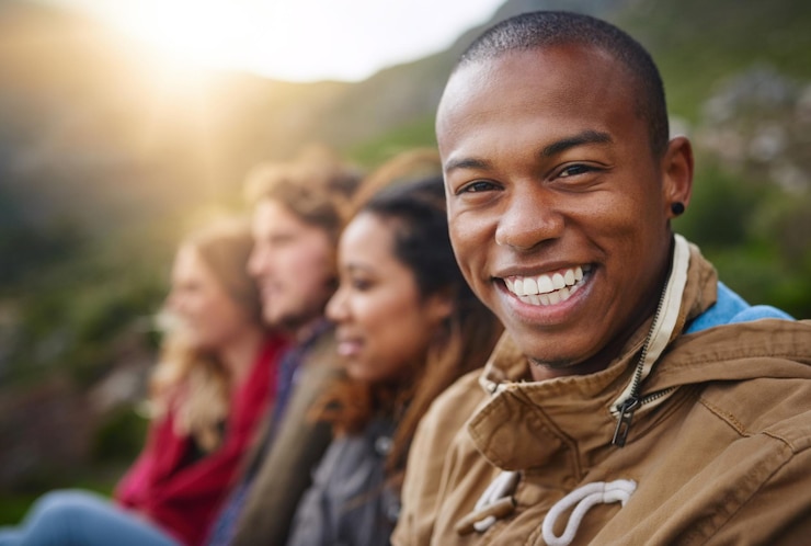 Photo portrait outdoor and man with friends vacation and smile in nature hangout and hiking in environment mountain adventure and reunion for happy people bonding and together for tourism and holiday