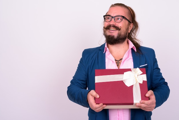 Portrait of overweight bearded businessman with mustache and long hair against white wall