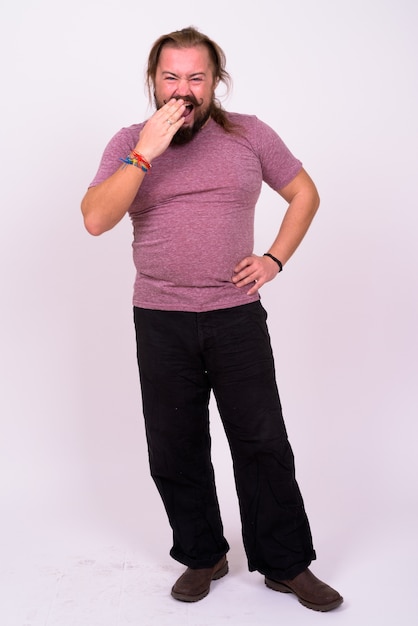 Photo portrait of overweight bearded man with mustache and long hair against white wall