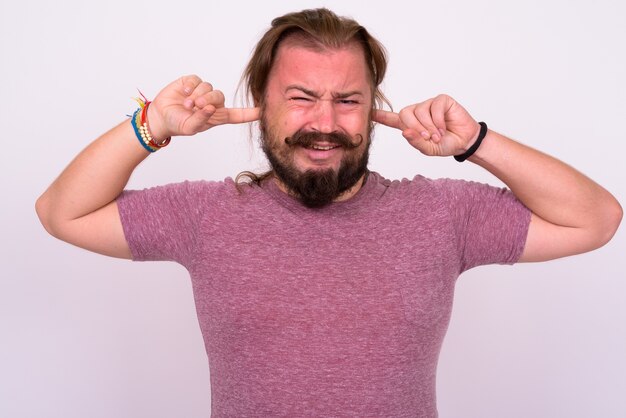 Portrait of overweight bearded man with mustache and long hair against white wall