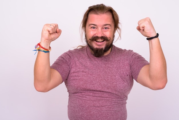 Portrait of overweight bearded man with mustache and long hair against white wall