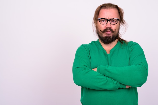 Portrait of overweight bearded man with mustache and long hair wearing green sweater against white wall