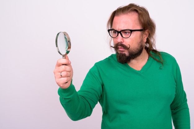 Photo portrait of overweight bearded man with mustache and long hair wearing green sweater against white wall