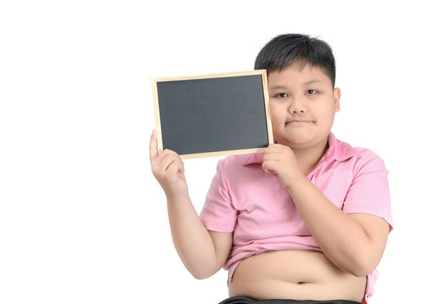 Photo portrait of overweight boy holding blank slate against white background