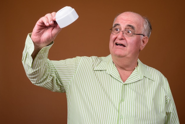 Portrait of overweight senior man holding coffee cup